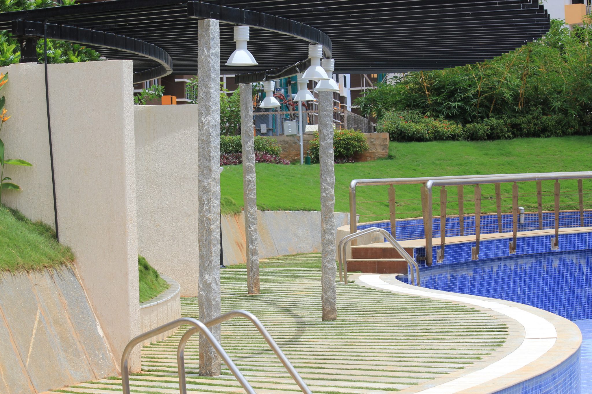Pool edge with blue tile and handrails